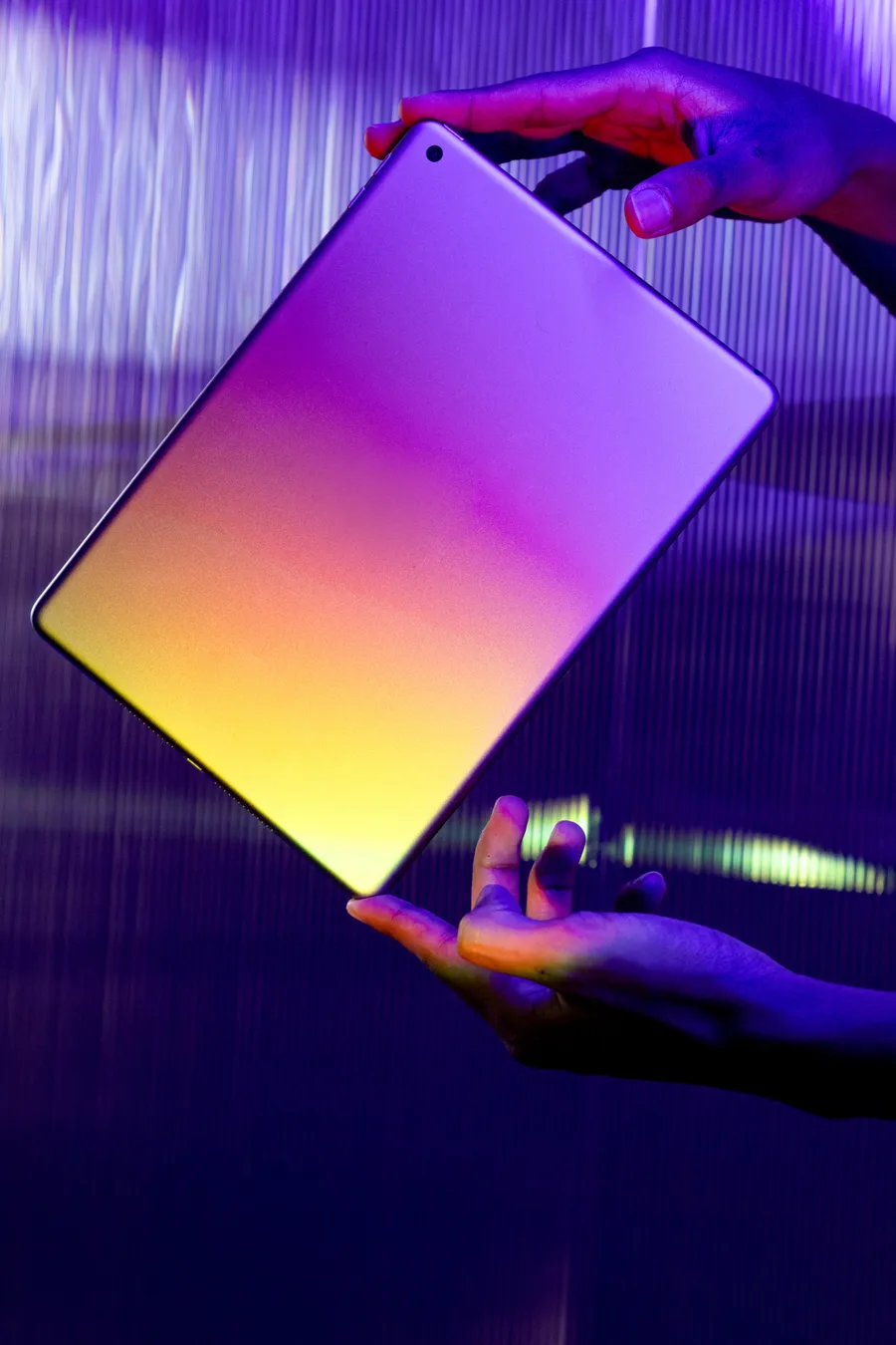 A glowing tablet held above a hand in violet light